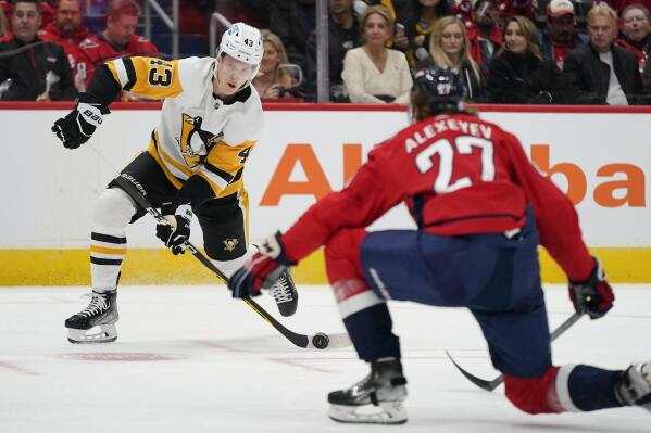 Pittsburgh Penguins left wing Danton Heinen, left, takes a shot on goal in front of Washington Capitals defenseman Alexander Alexeyev in the first period of an NHL hockey game, Wednesday, Nov. 9, 2022, in Washington. (AP Photo/Patrick Semansky)