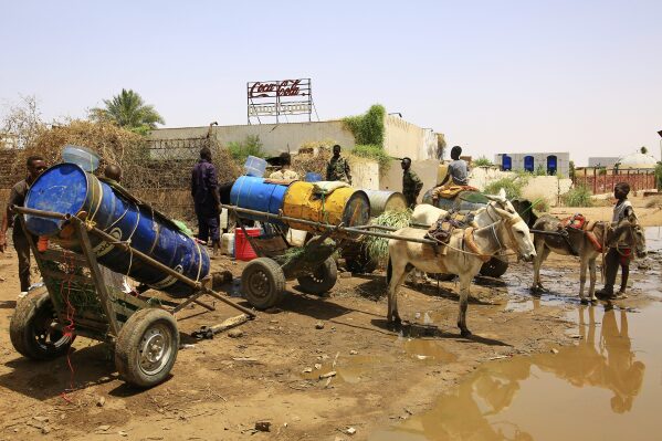 People fill water containers at a distribution point due to water outages in Khartoum, Sudan, Sunday, May 25, 2025. (AP Photo)