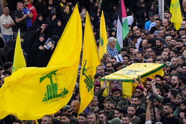 Hezbollah fighters carry the coffin of their comrade, Qassim Ibrahim Abu-Taam, who was killed along Lebanon's southern border with Israel, during his funeral procession in the southern Beirut suburb of Dahiyeh, Lebanon, Monday, Nov. 6, 2023. (AP Photo/Hassan Ammar)