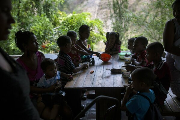 
              In this Feb. 14, 2019 photo, children eat in a soup kitchen where they scoop spoonfuls of rice and scrambled eggs in what could be their only meal of the day, in the Petare slum, in Caracas, Venezuela. Part of the tragedy of daily life in socialist Venezuela can be glimpsed in this small volunteer soup kitchen in the heart of one of Latin America’s biggest slums, which helps dozens of children as well as unemployed mothers who can no longer feed them. (AP Photo/Rodrigo Abd)
            