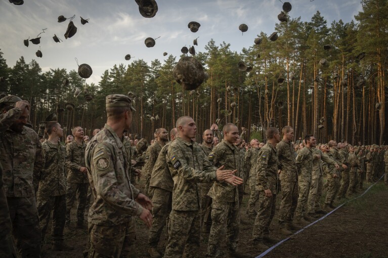 Newly recruited soldiers shout slogans as they celebrate the end of their training at a military base close to Kyiv, Ukraine, Monday, Sept. 25, 2023. (AP Photo/Efrem Lukatsky)