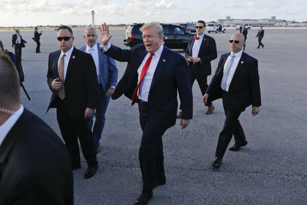
              President Donald Trump, center, surrounded by members of the Secret Service, walks across the tarmac to begin to greet supporters during his arrival at Palm Beach International Airport, Thursday, April 18, 2019, in West Palm Beach, Fla. Trump traveled to Florida to spend the Easter weekend as his Mar-a-Lago estate. (AP Photo/Pablo Martinez Monsivais)
            