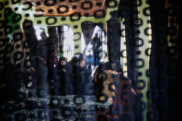 Shiite Muslim women pray on the other side of a curtain at the shrine of Peer Syed Mehndi on Nowruz, Persian New Year, in Srinagar, Indian controlled Kashmir, Friday, March 21, 2025. (AP Photo/Mukhtar Khan)