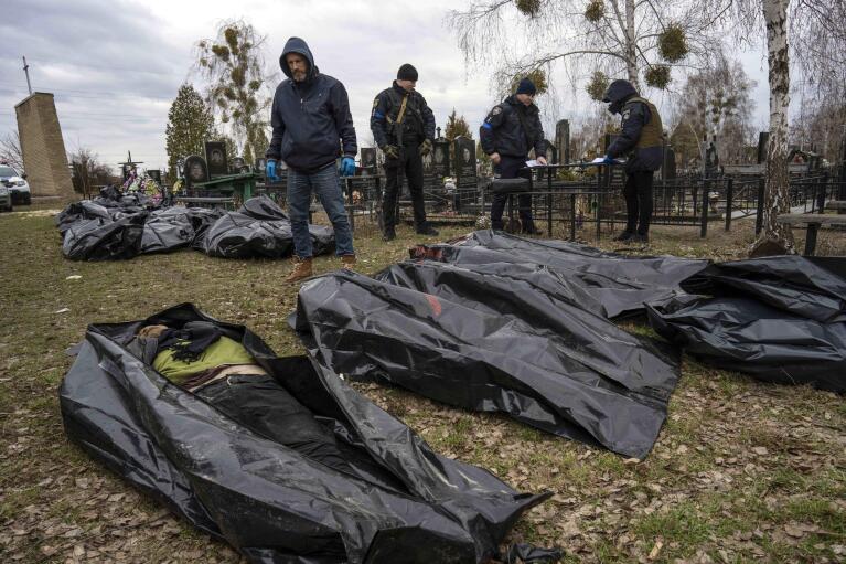 FILE - Police investigate the killing of civilians in Bucha, Ukraine on the outskirts of Kyiv, before bringing the corpses to a morgue, Wednesday, April 6, 2022. (AP Photo/Rodrigo Abd, File)