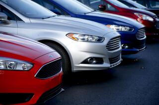 FILE - A row of new Ford Fusions are for sale on the lot at Butler County Ford in Butler, Pa., Nov. 19, 2015. A shortage of computer chips and other parts hobbled the U.S. auto industry in 2022, slowing factories and contributing to an expected 8% decline in sales from the previous year. And although supplies are improving and prices are coming down a little, auto factories aren't likely to get back to full production until next year. (AP Photo/Keith Srakocic, File)
