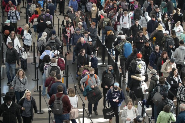 FILE - Travelers queue up to pass through the south security checkpoint in Denver International Airport on Dec. 23, 2022, in Denver. Thirty percent of Americans don't identify with a religious group — but not all of them are atheists or agnostics. In fact, 43% of the group known as the "nones" say they believe in God, even if they largely dislike organized religion. (AP Photo/David Zalubowski, File)