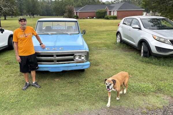 Ricky Dority poses for a photo with his 1969 GMC pickup and his family dog 