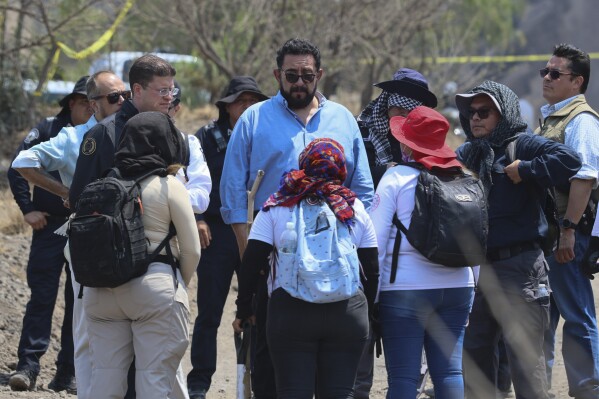 Mexico City interim Prosecutor Ulises Lara speaks with the mothers of missing children at the site where volunteer searchers said they found a clandestine crematorium in Tlahuac, on the edge of Mexico City, Wednesday, May 1, 2024. Ceci Flores, a leader of one of the groups of so-called searching mothers from northern Mexico, announced late Tuesday that her team had found bones around clandestine burial pits and ID cards, and prosecutors said they were investigating to determine the nature of the remains found. (AP Photo/Ginnette Riquelme)