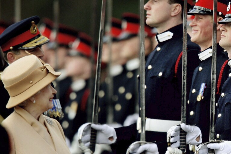 FILE - Britain's Prince Harry, second from right, grins as his grandmother Queen Elizabeth II smiles, as she inspects the Sovereign's Parade at the Royal Military Academy in Sandhurst, England, Wednesday, April 12, 2006. (AP Photo/Dylan Martinez, pool, File)