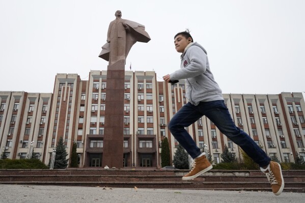 FILE - A boy runs past a statue of Soviet Union founder Vladimir Lenin in Tiraspol, the capital of the Russia-backed breakaway region of Transnistria, in Moldova on Nov. 1, 2021. Since Russia fully invaded Ukraine two years ago, a string of incidents in Transnistria have periodically raised the specter that European Union candidate Moldova could also be in Moscow's crosshairs. (AP Photo/Dmitri Lovetsky, File)