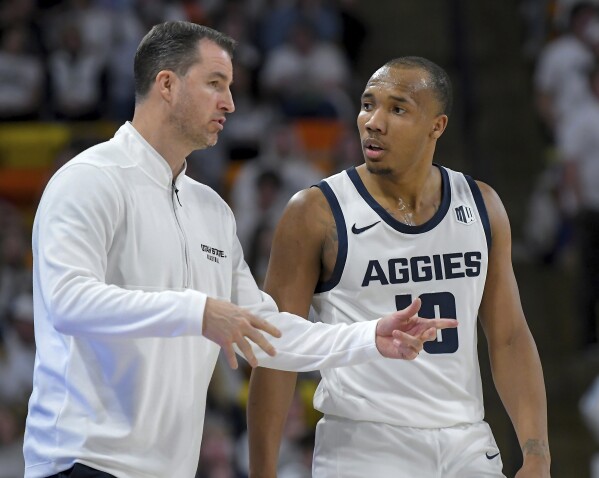 El entrenador en jefe del estado de Utah, Danny Sprinkle, habla con el guardia Darius Brown II (10) durante la segunda mitad de un partido de baloncesto universitario de la NCAA contra el estado de San José el martes 30 de enero de 2024 en Logan, Utah.  (Eli Lucero/Herald Journal vía AP)