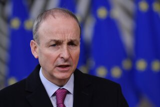 FILE - In this file photo dated Thursday, Dec. 10, 2020, Ireland's Prime Minister Micheal Martin speaks as he arrives at the European Council building in Brussels.  The Irish Prime Minister Micheal Martin seems poised to make a formal apology on behalf of the Irish state, for the deaths of thousands of infants and other abuses in church-run homes for unmarried women and their babies, following inquiry findings due to be published on Tuesday Jan. 12, 2021. (John Thys/ Pool FILE via AP)