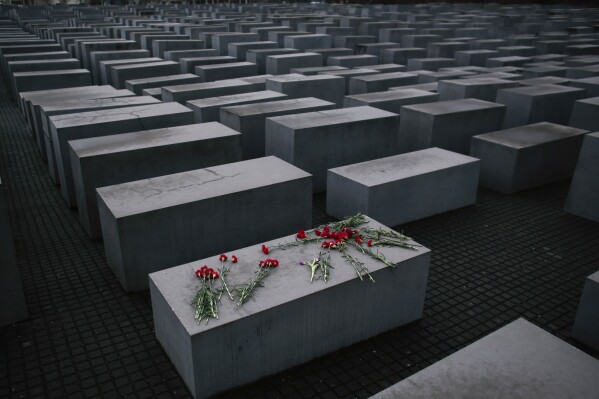 Flowers lie on a concrete slab of the Holocaust Memorial to mark the International Holocaust Remembrance Day and commemorating the 70th anniversary of the liberation of the Nazi Auschwitz death camp in Berlin, Jan. 27, 2015. (AP Photo/Markus Schreiber, File)