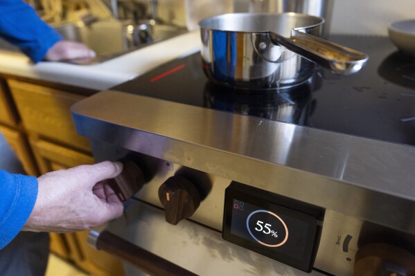 Ed Yaker boils water on a Copper stove, an electric induction stove, on Feb. 10, 2025, in New York. (AP Photo/John Minchillo)