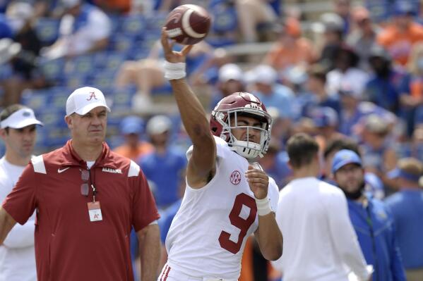 FILE - Alabama quarterback Bryce Young (9) warms up as offensive coordinator Bill O'Brien, left, watches before an NCAA college football game against Florida, on Sept. 18, 2021, in Gainesville, Fla. Young views the Heisman Trophy as about what he and Alabama have already done, not what the top-ranked Crimson Tide are still trying to accomplish in his first season as their starting quarterback. (AP Photo/Phelan M. Ebenhack, File)