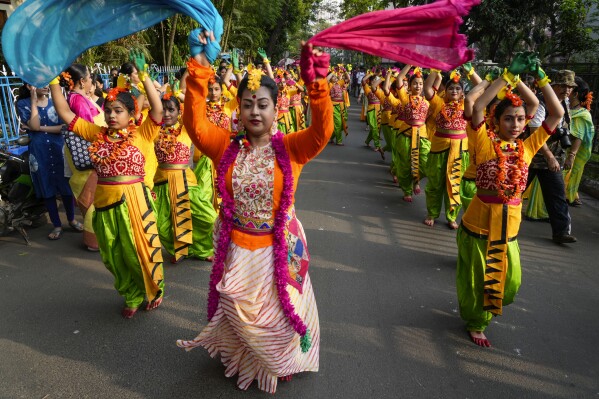 Women dance on a street while taking part in a procession to celebrate Holi, the festival of colors, in Kolkata, India, Monday, March 25, 2024. (AP Photo/Bikas Das)