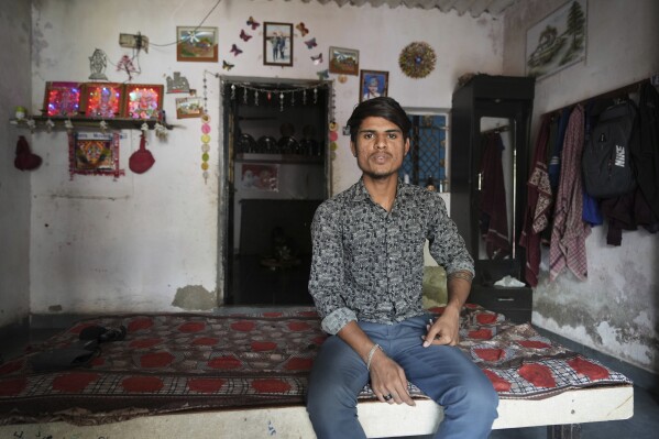 Veer Vanzara sits inside his house with reflective paint on the roof that helps keep the indoors cooler in Ahmedabad, India, Wednesday, April 2, 2025. (AP Photo/Ajit Solanki)