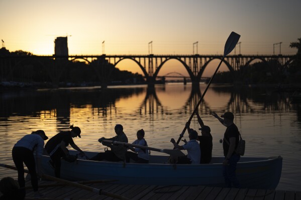 Ukrainians, a few of them displaced from Mariupol during the war, train at rowing on the Dnipro river as the sun sets, in Dnipro, Ukraine, Thursday, May 2, 2024. (AP Photo/Francisco Seco)