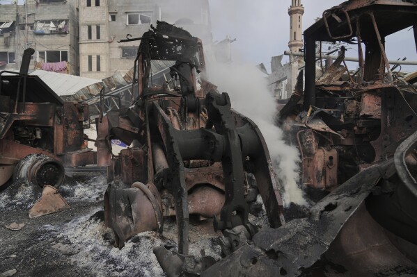 Smoke rises from the remains of bulldozers hit by an Israeli army airstrike in Jabaliya, northern Gaza Strip, on Tuesday, April 22, 2025. (AP Photo/Jehad Alshrafi)