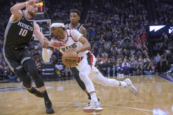 Portland Trail Blazers guard Keon Johnson drives to the basket past Sacramento Kings forward Domantas Sabonis (10) during the first quarter of an NBA basketball game in Sacramento, Calif., Thursday, Feb. 23, 2023. (AP Photo/Randall Benton)