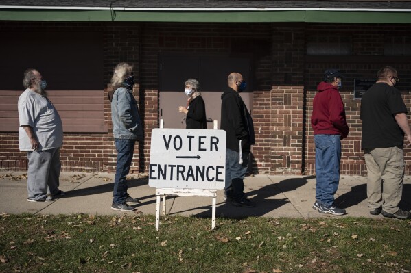 FILE - In this Nov. 3, 2020 file photo, voters wait in line outside a polling center on Election Day, in Kenosha, Wis. Wisconsin voters are being asked to make it unconstitutional to accept private grant money to help administer elections, a Republican-backed effort in the ongoing battle over how to run elections in the presidential battleground state. That proposed constitutional amendment, along with a related one saying that only election officials designated by law may administer elections, are both on the state's April 2, 2024 ballot. (AP Photo/Wong Maye-E, File)