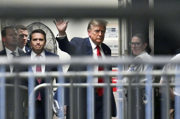 Former President Donald Trump waves as he returns to the courtroom after a break at Manhattan Criminal Court on Monday, April 15, 2024, in New York. The hush money trial of Trump begun Monday with jury selection. (Angela Weiss/Pool Photo via AP)