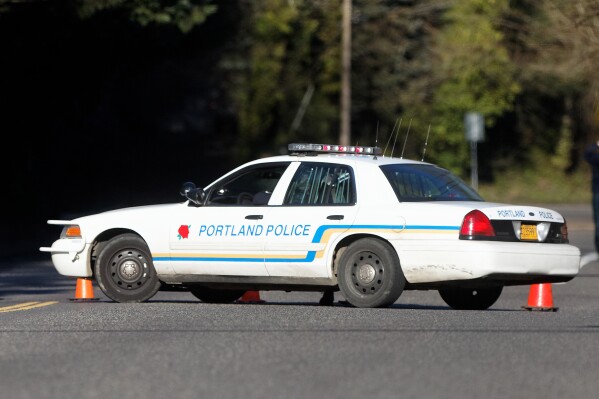 FILE - A Portland police vehicle is parked at a crime scene in Portland, Ore., on March 12, 2014. Authorities in Oregon say the deaths of four women whose bodies were found over three months starting in February 2023, with the last one found in May, are linked and that at least one person of interest has been identified. In Portland, the Multnomah County District Attorney's office says no charges have been filed against anyone but added that the community is not currently in any danger. (Mike Zacchino/The Oregonian via AP, File)