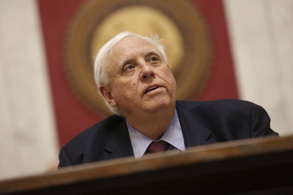 FILE - West Virginia Gov. Jim Justice delivers his State of the State address, Jan. 10, 2024, in Charleston, W.Va. Justice's administration has been characterized by flat budgets and record-high surpluses that were used to cut the state’s income tax last year — a law he signed a month before announcing a run for U.S. Sen. Joe Manchin's seat. (AP Photo/Chris Jackson, File)