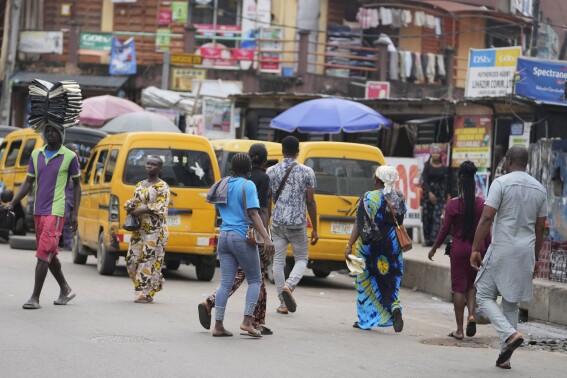Pedestrians cross a busy streets in Lagos, Nigeria, Tuesday Sept. 5, 2023. Made up of hundreds of thousands of members, the Nigeria Labor Congress workers association began Tuesday a two-day “warning strike,” in protest of the growing cost of living due to the removal of gas subsidies, threatening to “shut down” Africa’s largest economy if their demands for improved welfare are not met. their second in over a month. (AP Photo/Sunday Alamba)