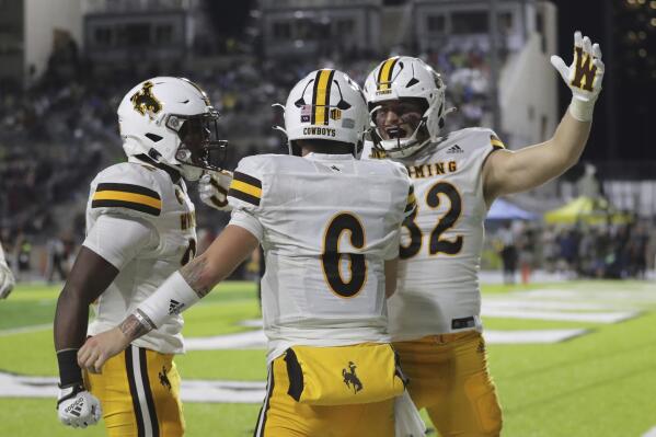 Wyoming quarterback Andrew Peasley (6) reacts with teammates after making a touchdown against Hawaii during the first half of an NCAA college football game on Saturday, Oct. 29, 2022, in Honolulu. (AP Photo/Marco Garcia)