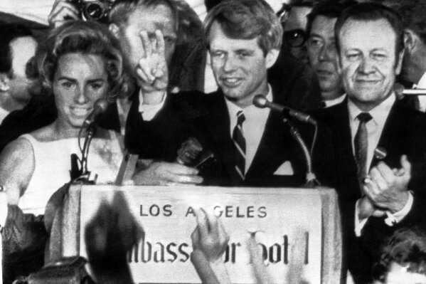 
              FILE - In this June 5, 1968 file photo, presidential hopeful Sen. Robert F. Kennedy waves goodbye to his supporters as he prepares to leave the Ambassador Hotel ballroom in Los Angeles, before exiting through a kitchen backatage. A day after meeting his hero Robert Kennedy, hotel busboy Juan Romero raced to congratulate the senator moments after his victory in the California presidential primary. After Kennedy briefly paused to shake the hand of the Mexican-born 17-year-old, an assassin gunned down Kennedy in front of Romero, fostering a guilt that would last for decades. (AP Photo/Dick Strobel, File)
            