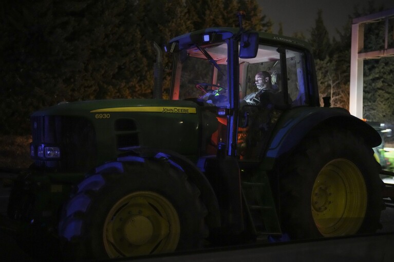 2024年1月30日火曜日、フランス南部エクスアンプロヴァンスの高速道路の検問所でトラクターの中で一晩を過ごす農民。(AP写真/ダニエル・コール)