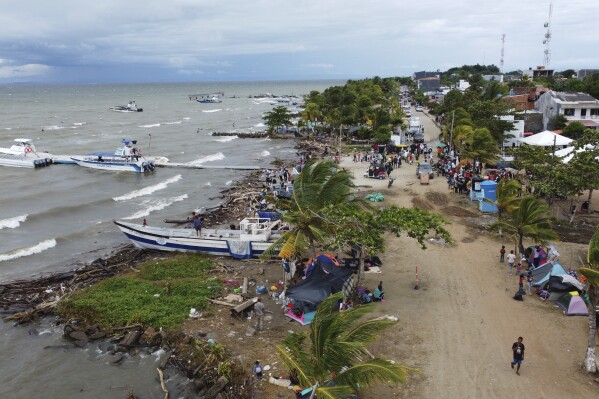 FILE - Migrants gather in Necocli, Colombia, a stopping point for migrants taking boats to Acandi which leads to the Darien Gap, Oct. 13, 2022. The flow of thousands of migrants daily through the migratory highway, the Darien Gap, has been cut off following the Feb. 26, 2024 capture in Necoclí of some boat captains who had been ferrying the migrants to the starting point of their jungle trek. (AP Photo/Fernando Vergara, File)