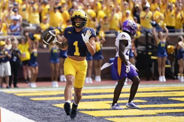 Michigan wide receiver Roman Wilson (1) celebrates his touchdown reception as East Carolina defensive back Isaiah Brown-Murray (26) defends in the first half of an NCAA college football game in Ann Arbor, Mich., Saturday, Sept. 2, 2023. (AP Photo/Paul Sancya)
