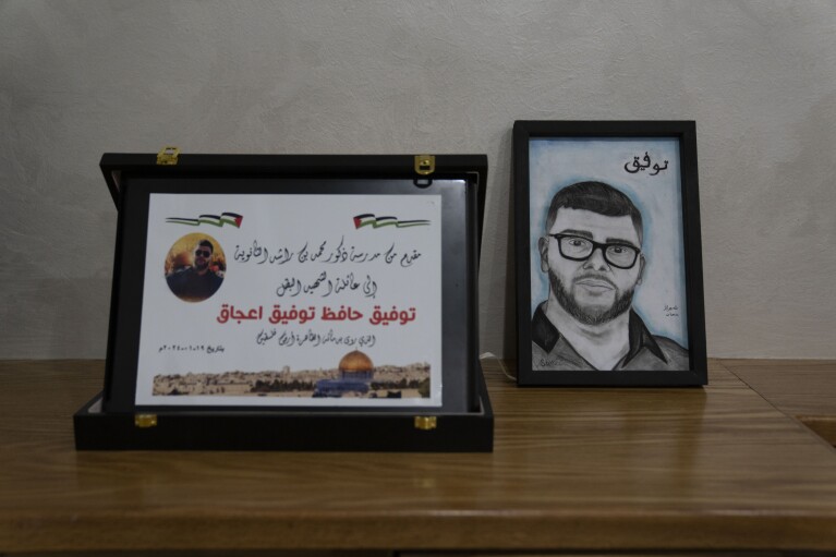 A card honoring 17-year-old Tawfic Abdel Jabbar, a teenager from Louisiana who was fatally shot last week, is displayed next to a drawing of him to commemorate him, at the family's Palestinian home village of Al-Mazra'a ash-Sharqiya, West Bank, Tuesday, Jan. 23, 2024. (AP Photo/Nasser Nasser)
