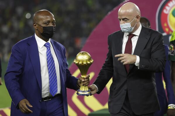 FILE- CAF President Patrice Motsepe, left, and FIFA President Gianni Infantino hold the African Cup of Nations 2022 trophy after the final soccer match between Senegal and Egypt at the Olembe stadium in Yaounde, Cameroon, on Feb. 6, 2022. (AP Photo/Sunday Alamba, File)