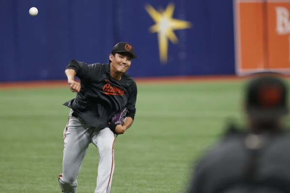 Baltimore Orioles relief pitcher Shintaro Fujinami warms up in the outfield during batting practice before playing against the Tampa Bay Rays in a baseball game Friday, July 21, 2023, in St. Petersburg, Fla. (AP Photo/Scott Audette)