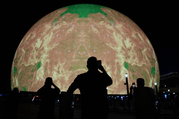 People take pictures during the opening night of the Sphere, Friday, Sept. 29, 2023, in Las Vegas. (AP Photo/John Locher)