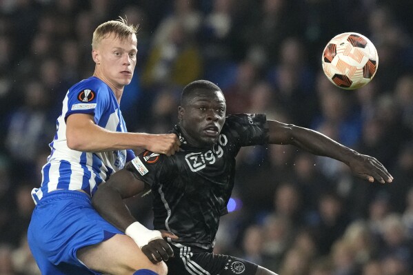 Brighton's Jan Paul van Hecke, left, challenges for the ball with Ajax's Brian Brobbey during the Europa League Group B soccer match between Brighton and Hove Albion and Ajax at the Amex stadium in Brighton, England, Thursday, Oct. 26, 2023. (AP Photo/Frank Augstein)