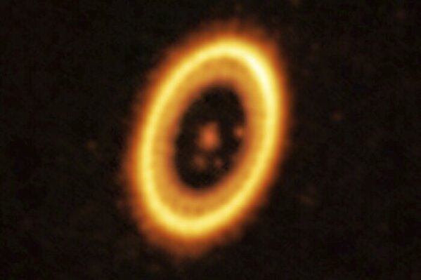 This image, taken with the Atacama Large Millimeter/submillimeter Array (ALMA), shows the young planetary system PDS 70, located nearly 400 light-years away from Earth. Astronomers have discovered what could be two planets sharing the same orbit around their star. They say it's the strongest evidence yet of this bizarre cosmic pairing. long suspected but never proven. The researchers published their findings on Wednesday, July 19, 2023. (European Southern Observatory via AP)