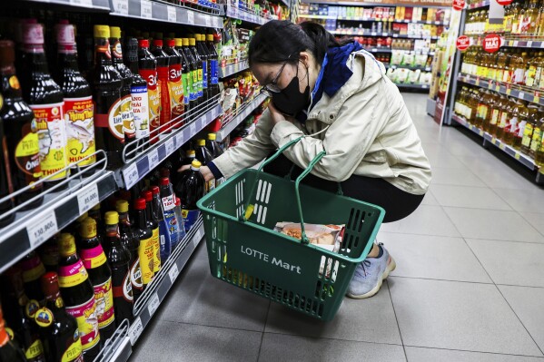 A woman purchases a bottle of fish sauce at Lotte Mart West Lake on March 10, 2025, in Hanoi, Vietnam. (AP Photo/Yannick Peterhans)