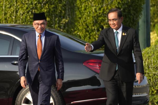 Malaysia's Prime Minister Anwar Ibrahim, left, and Thailand's Prime Minister Prayuth Chan-ocha arrive to review an honor guard during a welcoming ceremony at the Government House in Bangkok, Thailand, Thursday, Feb. 9, 2023. (AP Photo/Sakchai Lalit)