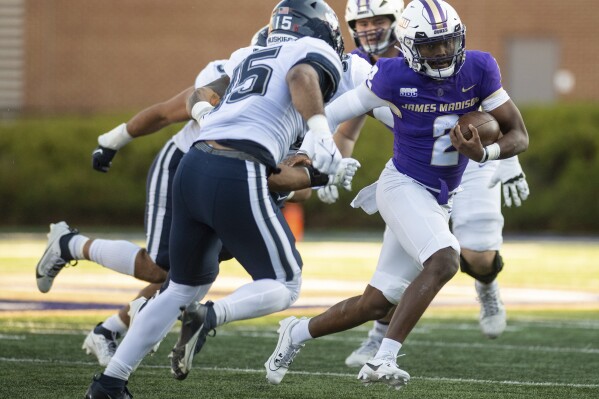 James Madison quarterback Jordan McCloud (2) carries the ball up the field during the first half of an NCAA college football game against Connecticut in Harrisonburg, Va., Saturday, Nov. 11, 2023. (Daniel Lin/Daily News-Record via AP)