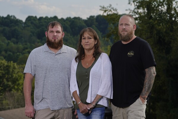 Karen Goodwin, center, and her husband, Brian, right, stand for a portrait with their son, Dustin Talley, Friday, Sept. 22, 2023, in Bristol, Tenn. Goodwin's younger son, Austin Hunter Turner, died after an encounter with the Bristol Police Department in 2017. (AP Photo/George Walker IV)