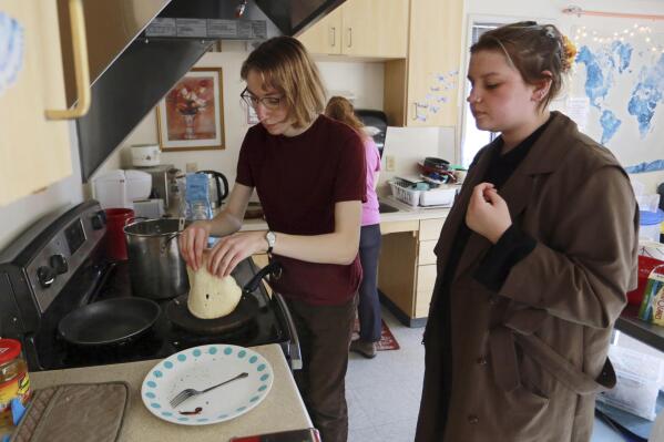 Students Sophia Pavlenko, left, of Russia, and Masha Novikova, of Ukraine, prepare blini, the Eastern European-style crepes, to sell to fellow students in a dorm at the United World College, Sunday, March 12, 2022, in Montezuma, N.M. At the boarding school in the Rocky Mountains, a group of Eastern European teenagers made crepes to raise money for the millions of people whose lives have been uprooted by Russia’s war on Ukraine. (AP Photo/Cedar Attanasio)
