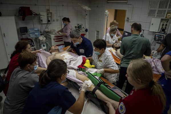 Medical staff move a seriously wounded Ukrainian serviceman at the ICU department of Mechnikov Hospital in Dnipro, Ukraine, Friday, July 14, 2023. A surge of wounded soldiers has coincided with the major counteroffensive Ukraine launched last month to try to recapture its land from Russian forces. Surgeons at the Mechnikov Hospital, one of the country's biggest, are busier now than perhaps at any other time since Russia began its invasion 17 months ago. (AP Photo/Evgeniy Maloletka)