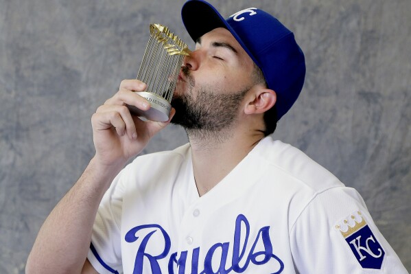FILE - Kansas City Royals' Eric Hosmer kisses a replica APSeries trophy as he poses for a photographer during photo day at spring training baseball Thursday, Feb. 25, 2016, in Surprise, Ariz. Hosmer announced his retirement from baseball Wednesday, Feb. 21, 2024, following a 13-year career that included winning four Gold Gloves and helping lead Kansas City to victory in the 2015 APSeries.(APPhoto/Charlie Riedel, File)