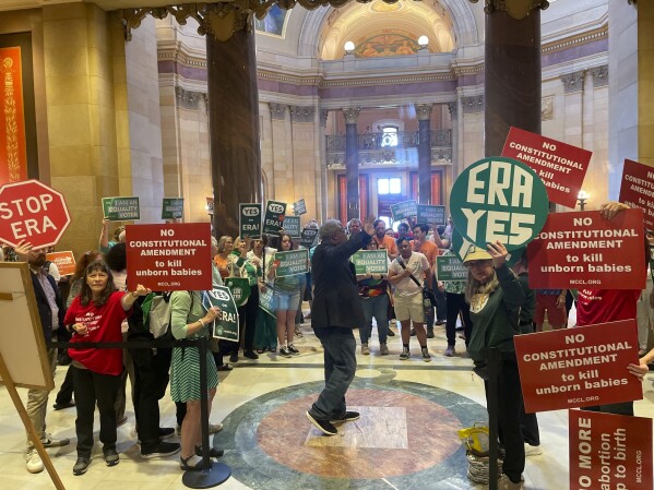 Dozens of supporters and opponents of the Minnesota Equal Rights Amendment legislation held signs – green in support, red in opposition – outside the Minnesota House chamber in the State Capitol building in St. Paul, Minn., on Monday, May 13, 2024, ahead of a crucial House floor vote on the legislation. The amendment would guarantee some of the country's most expansive protections of abortion and LGBTQ+ rights if it is approved by both chambers this session and then by voters in two years. (AP Photo/Trisha Ahmed)