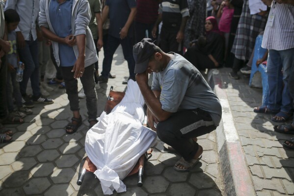 Palestinians mourn over the bodies of relatives killed in an Israeli airstrike, outside the morgue in Al-Aqsa Martyrs Hospital in Deir al Balah, the Gaza Strip, Monday, June 10, 2024. (AP Photo/Jehad Alshrafi)
