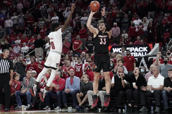 Louisville forward Matt Cross (33) shoots a 3-point basket to take the lead late in the second half while North Carolina State guard Terquavion Smith (0) defends during an NCAA college basketball game in Raleigh, N.C., Saturday, Dec. 4, 2021. (AP Photo/Gerry Broome)